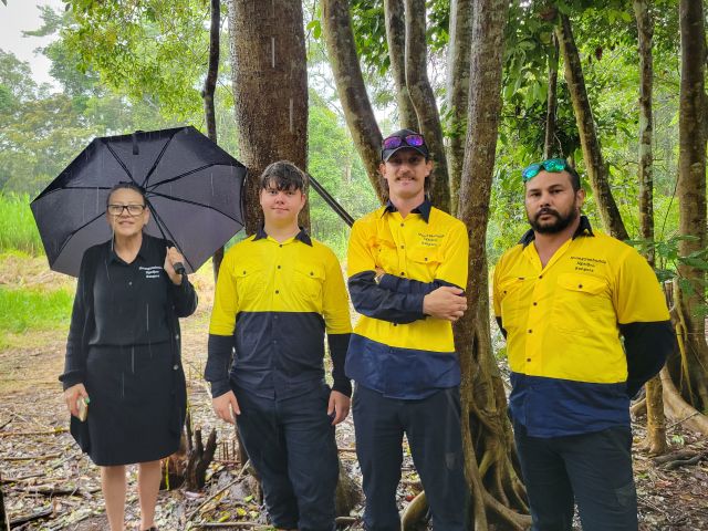 Photo of three rangers and an officer in a forest in rain